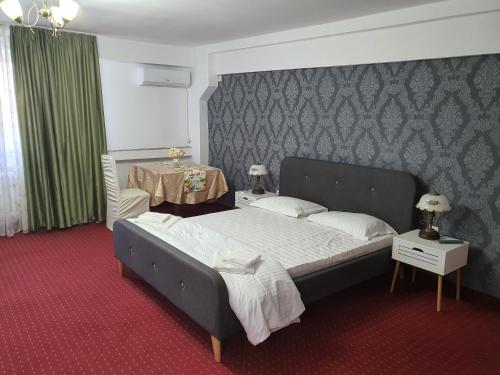 a bedroom with a large bed and a table at BON TON Residence in Drobeta-Turnu Severin