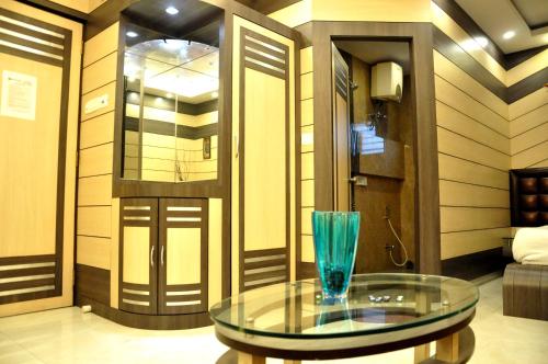 a glass table with a vase on it in a room at Hotel Esteem in Kolkata