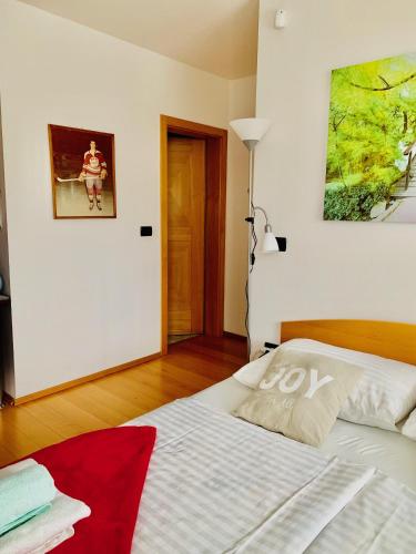 a white bed in a room with a painting on the wall at Rudi Hiti's Guest House in Bled