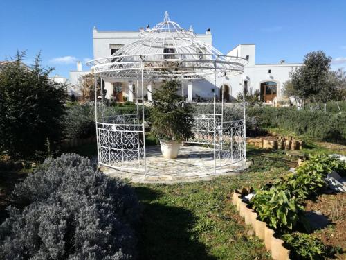 a metal gazebo in the middle of a garden at Tenuta Patruno Perniola in Gioia del Colle