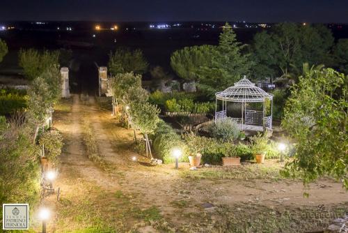a garden with a gazebo and trees at night at Tenuta Patruno Perniola in Gioia del Colle