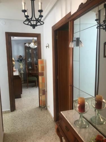 um corredor com um espelho e uma mesa com copos de vinho em ALOJAMIENTO LA EXPLANADA em Pegalajar
