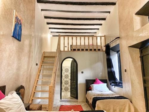 a bedroom with a bed and a staircase at Riad Beldy in Essaouira