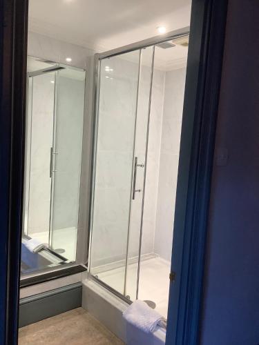 a bathroom with a glass shower stall in a room at The Mooring Post in Gloucester