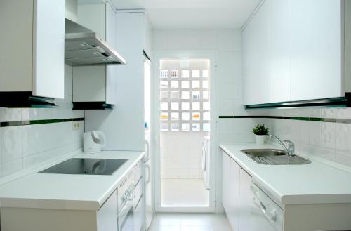 マルベーリャにあるLovely Puerto Banus Apartmentの白いキッチン(白いカウンター、シンク付)