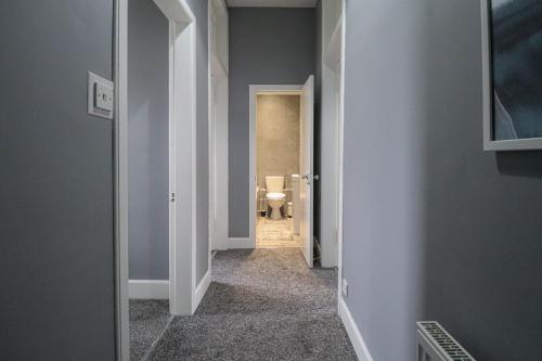 a hallway with a toilet in a bathroom at Cosy Seaside Princes Apartment in Helensburgh