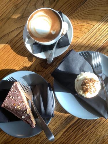 uma mesa com pratos de comida e uma chávena de café em The Mooring Post em Gloucester