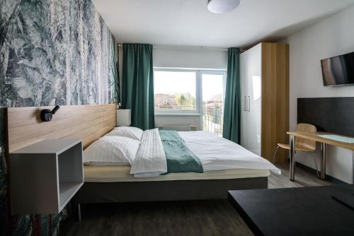a bedroom with a large bed and a window at Apartmán Lenka in Veľký Meder