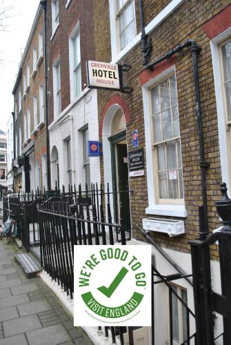 a sign on a fence in front of a hotel at Grenville House Hotel in London