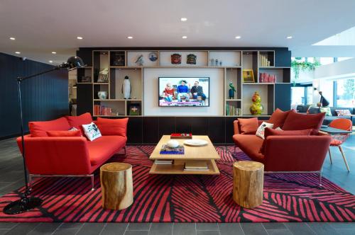 a living room with two red chairs and a coffee table at citizenM Kuala Lumpur Bukit Bintang in Kuala Lumpur