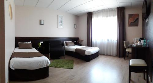 a hotel room with two beds and a window at Hôtel Particulier VILLA DES MARAIS in La Chevrolière