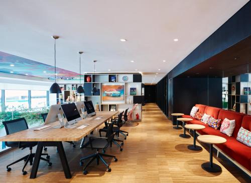 an office with a long table and chairs and a couch at citizenM Kuala Lumpur Bukit Bintang in Kuala Lumpur