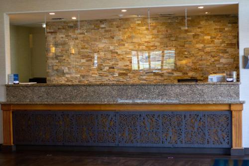 eine Bar in einer Lobby mit einer Steinmauer in der Unterkunft Best Western Plus A Wayfarer's Inn & Suites in Kingman