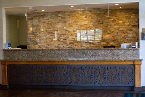 a bar in a lobby with a stone wall at Best Western Plus A Wayfarer's Inn & Suites in Kingman