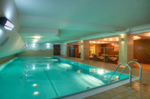 a large swimming pool in a hotel room at Maximus Spa in Dziwnówek