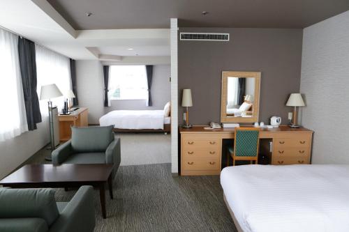 a hotel room with a bed and a desk at Hotel Premium Green Hills in Sendai