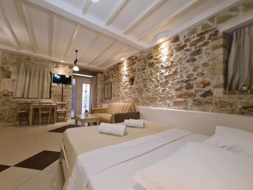 een slaapkamer met een bed en een stenen muur bij NJ Corfu Liston Apartments in Corfu-stad