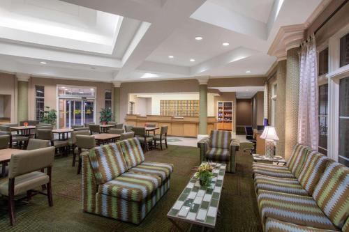un restaurante con sofás, mesas y sillas en La Quinta by Wyndham Denver Southwest Lakewood, en Lakewood