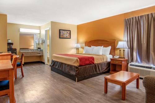 una habitación de hotel con una cama y un baño en Econo Lodge Inn & Suites, en Evergreen
