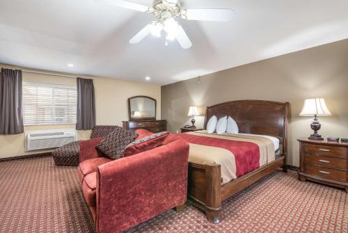 a hotel room with a bed and a chair at Econo Lodge Inn & Suites Bryant in Bryant