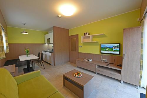 a living room with a couch and a television at Hotel Jirinka in Dolní Morava