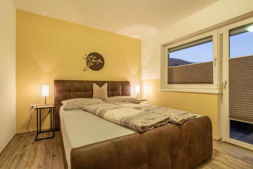 sypialnia z dużym łóżkiem i oknem w obiekcie Apart Manuel w Mayrhofen