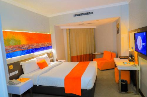 a hotel room with a bed and an orange chair at Citymax Hotel Aswan in Aswan