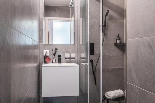a bathroom with a white sink and a shower at Ascot-Zermatt in Zermatt