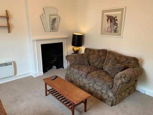 uma sala de estar com um sofá e uma mesa em High Street Flat em Sherborne