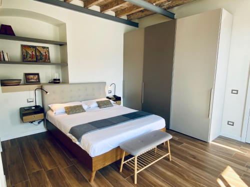 a bedroom with a large bed and a chair at Via Castello, Lake Como, Brienno in Brienno