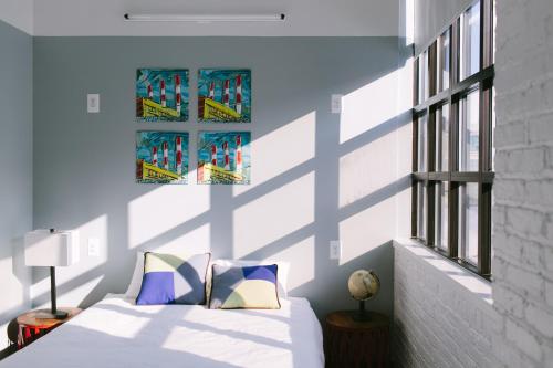 a bedroom with a bed and a blue wall at The Local NY in Queens