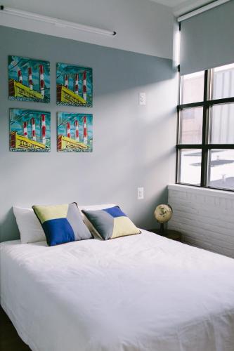 a bedroom with a large white bed and a window at The Local NY in Queens