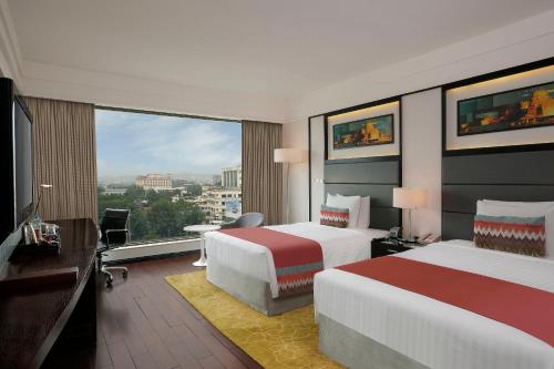 Cette chambre comprend deux lits et une grande fenêtre. dans l'établissement Crowne Plaza Pune City Centre, an IHG Hotel, à Pune