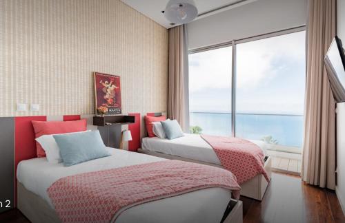 - 2 lits dans une chambre avec une grande fenêtre dans l'établissement Luxury villa Carlota with private pool by HR Madeira, à Caniço