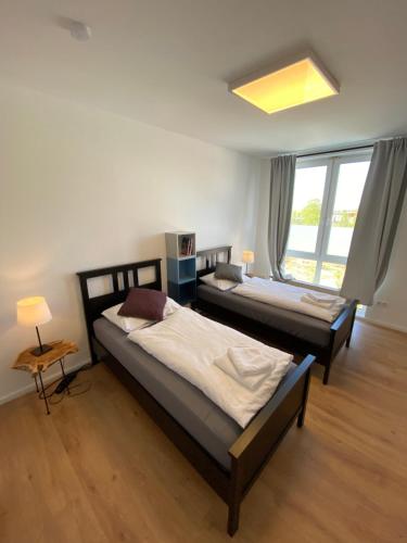 two beds in a room with a window at Business Apartment near Neuss/Düsseldorf in Korschenbroich