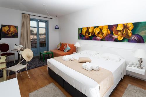 Un dormitorio con una cama blanca y una pintura en la pared en Operetta House, en Lárnaca