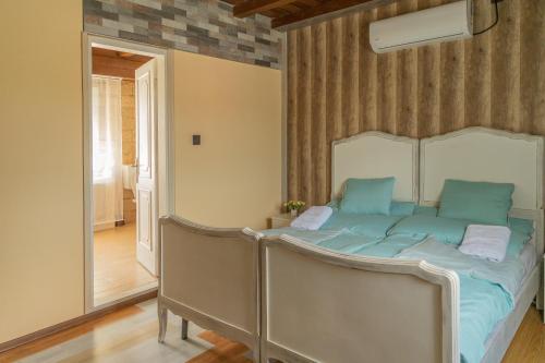 a bedroom with a bed with blue sheets on it at Fortuna Vendégház in Kiskunhalas
