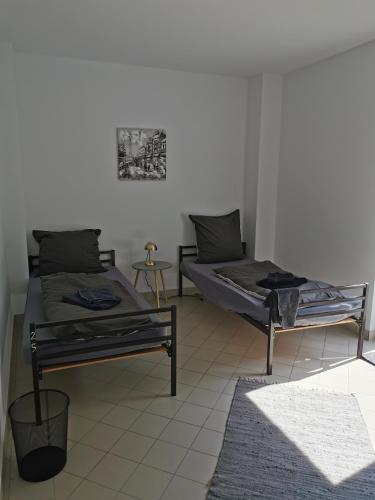 two beds sitting in a room with a rug at Zimmervermietung Lindenberg in Eckartsberga