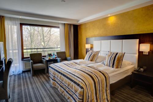 a hotel room with a large bed and a window at Hotel Moers van der Valk in Moers