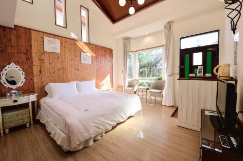 a bedroom with a bed and a television in it at Starhome Cottage in Ren'ai