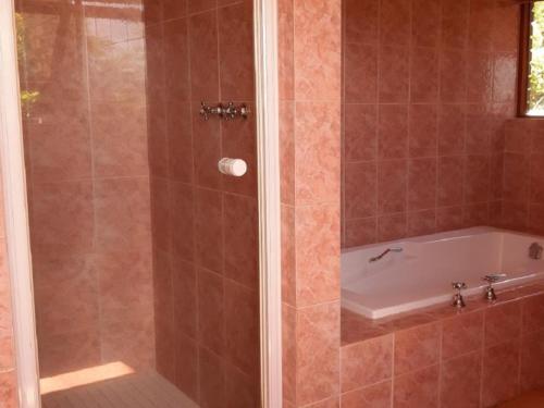 łazienka z prysznicem i wanną w obiekcie Amberley Mountain Reserve w mieście Dullstroom