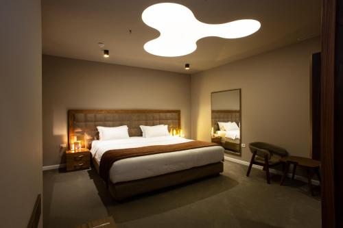 a bedroom with a large bed and a large light fixture at Best Western Premier Ark Hotel in Tirana