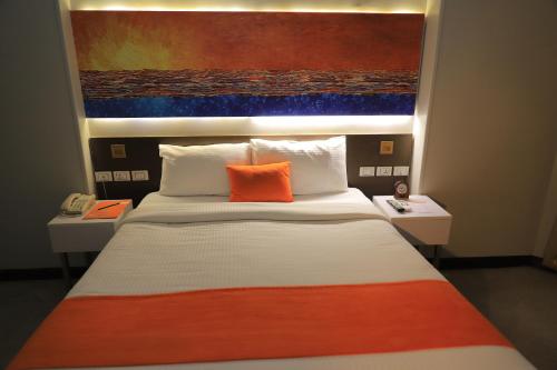 a bedroom with a bed with an orange pillow on it at Citymax Hotel Aswan in Aswan