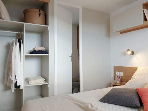 - une chambre avec un lit et un placard dans l'établissement Mobilhome la carabasse, à Vias