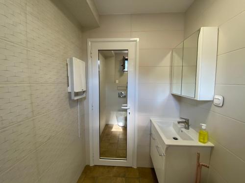 a white bathroom with a sink and a mirror at Coziness and comfort in the Old Town in Veliko Tŭrnovo
