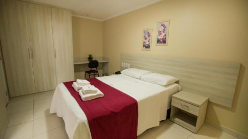 1 dormitorio con 1 cama con toallas en Reis Palace Hotel, en Petrolina