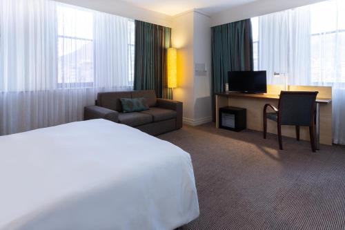a hotel room with a bed and a chair and a desk at Holiday Inn Express Cape Town City Centre by IHG in Cape Town