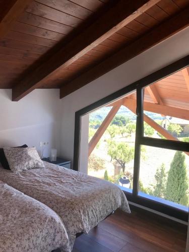 a bedroom with a bed and a large window at Chez Chloe in Murillo de Gállego