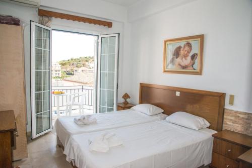 a bedroom with a bed and a large window at Limani Apartments in Kassiopi
