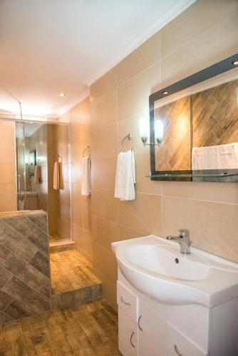 a bathroom with a sink and a shower at Limani Apartments in Kassiopi
